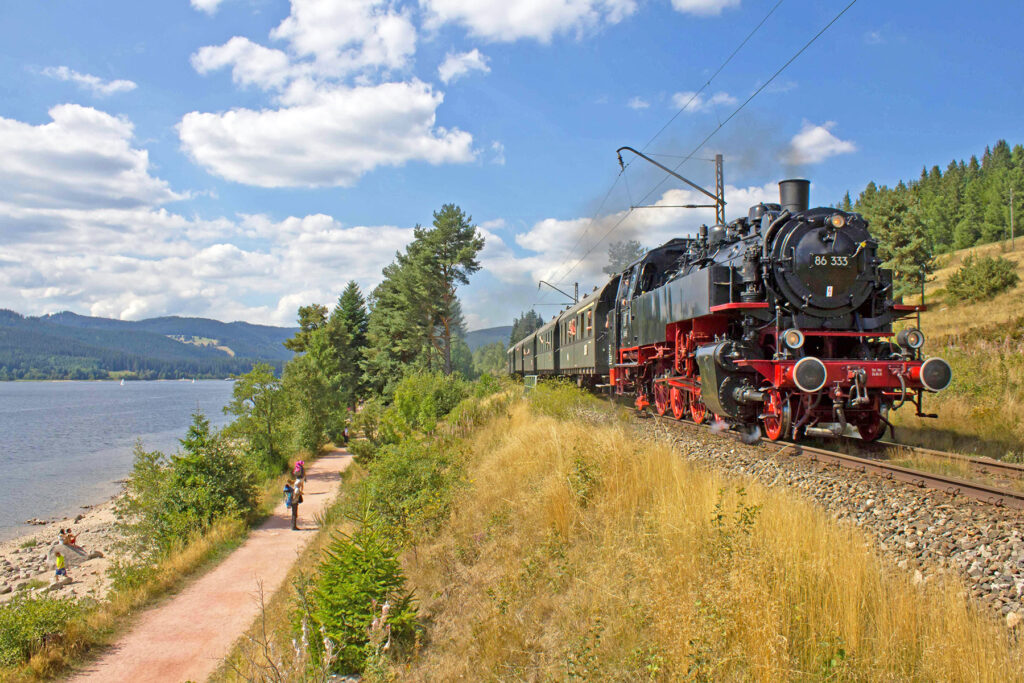 Historische Dampflok der 3Seenbahn fährt entlang des Schluchsees im Schwarzwald – nostalgische Zugfahrt mit der Drei-Seen-Bahn durch die Natur des Hochschwarzwalds.