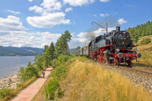 Historische Dampflok der 3Seenbahn fährt entlang des Schluchsees im Schwarzwald – nostalgische Zugfahrt mit der Drei-Seen-Bahn durch die Natur des Hochschwarzwalds.